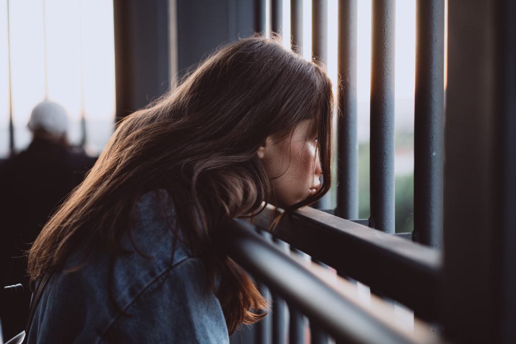 Young girl portrait behind an iron fence
